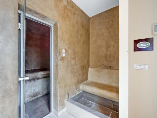 a walk in shower with a bench in a bathroom at Peaceful Getaway with Spa in Avelgem