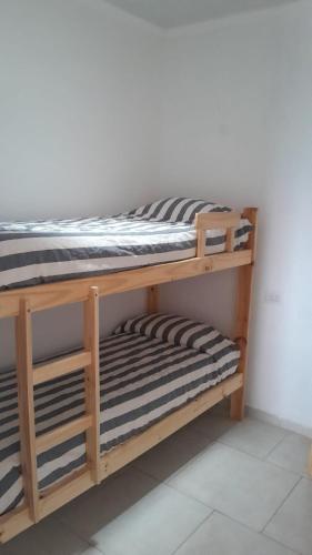 a wooden bunk bed with two empty shelves at La Goldie in Concepción del Uruguay