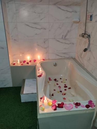 a bathroom with a bath tub filled with flowers and candles at Hotel Diamante Azul in Huancayo