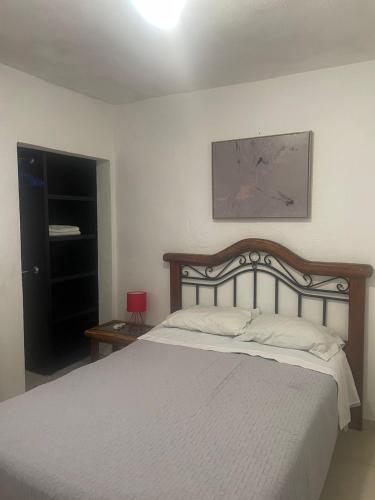 a bedroom with a large bed with a wooden headboard at Casa Perfectamente Ubicada in Tampico