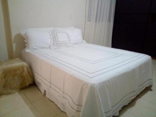 a white bed with white sheets and pillows at Rancho Nobre Produções TEMPORADA MOTO GP GOIÂNIA 5min, autódromo in Senador Canedo