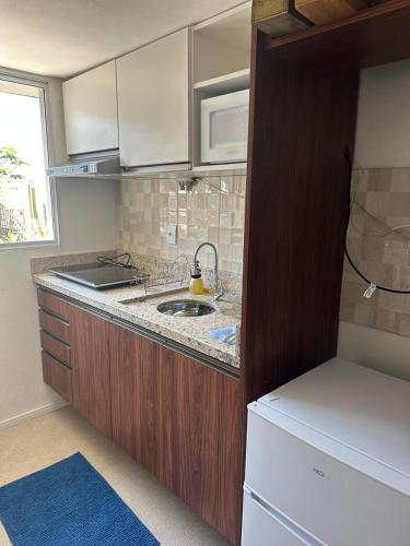 a kitchen with a sink and a microwave at Casas Temáticas in Tramandaí
