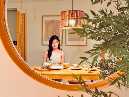 a woman sitting at a table in front of a mirror at JAJA Haenggung, SuwonㅣNext to Hwaseong FortressㅣCozy Korean VibeㅣComfortable & Well-keptㅣUp to 8 guestsㅣFree ParkingㅣLoved by many guests in Suwon