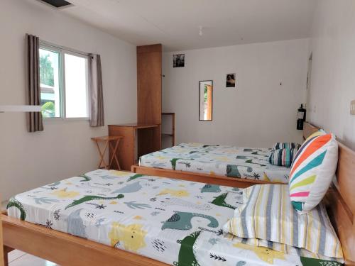 a bedroom with two beds and a window at Kathleens Vacation Place in Moalboal