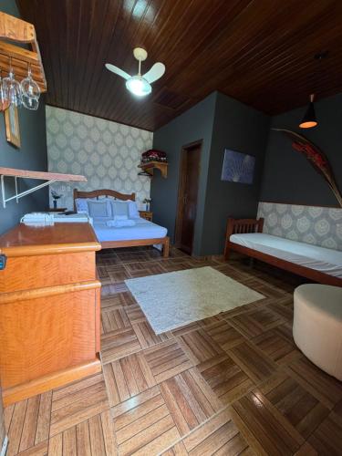 a bedroom with two beds and a wooden floor at Chácara Bora Bora in São Bento do Sapucaí