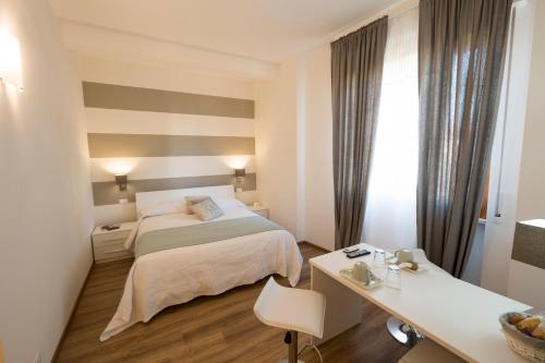 Habitación de hotel con cama y escritorio en Suite Simonetta, en Sarzana
