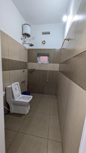 a small bathroom with a toilet and a window at Mountain Mist Ranipuram in Kallar