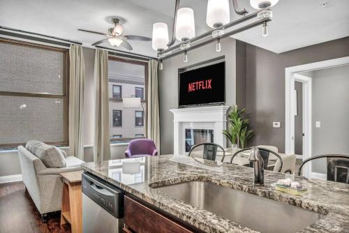 a kitchen with a sink and a living room at Upscale Downtown Loft | Parking • Gym in Cleveland