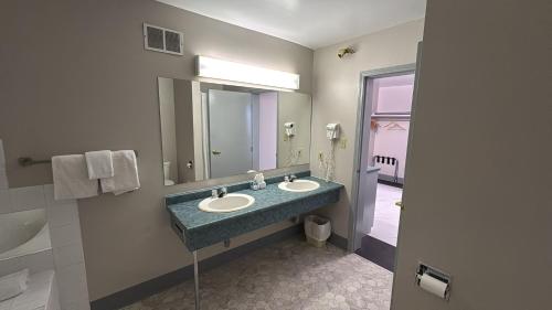 a bathroom with two sinks and a large mirror at Burntwood Hotel and Restaurant in Thompson