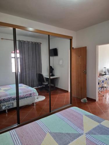 a bedroom with a mirror and a bed and a desk at Confort Suite 01 in Contagem