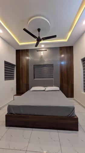 a bedroom with a bed with a ceiling fan at Mountain Mist Ranipuram in Kallar