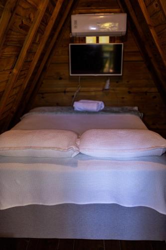 a bed in a attic with a tv on top at Cabana Suiça 2 in Guaramiranga