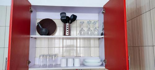 a red cabinet with dishes and utensils in it at Serene Hills Home in Nairobi