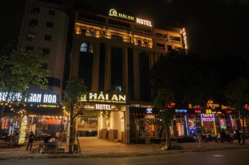 a building with shops on a street at night at Hai An Hotel Suites Ha Noi in Hanoi