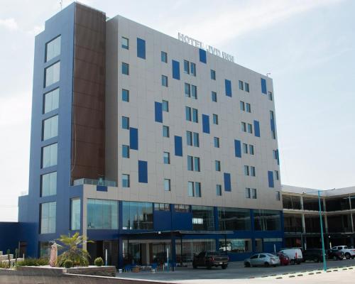 a large building with cars parked in a parking lot at Hotel JVD Inn - Tonalá Centro GDL in Guadalajara