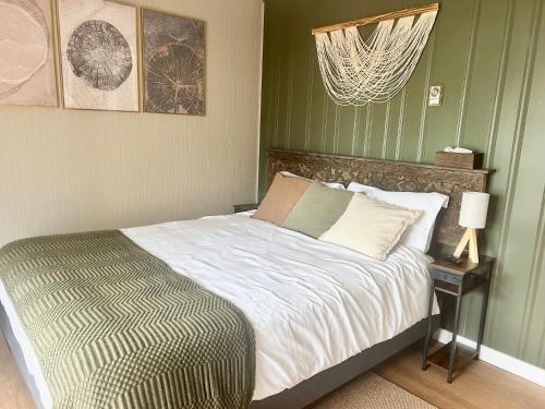 a bed in a bedroom with a green wall at Maple Woods B&B in Honeymoon Bay