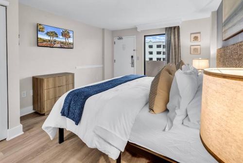 a bedroom with a large white bed with a window at Last Chance Summer, Oceanfront Pools and Beach in Myrtle Beach