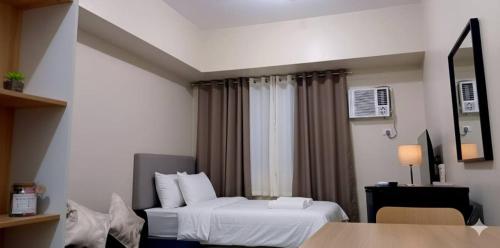 a hotel room with a bed and a window at The Suite Pod I CDO CondoStaycation - U26 in Cagayan de Oro