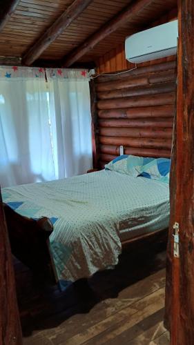 a bedroom with a bed in a wooden cabin at Cabañas El Macuco in Dos de Mayo