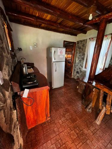 a kitchen with a white refrigerator in a room at Cabañas El Macuco in Dos de Mayo