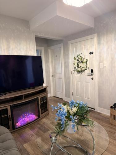 a living room with a tv and flowers on a table at Cozy & Near Downtown & Hyde Park in Chicago