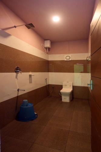 a small bathroom with a toilet and a shower at Snow Drops Resort in Vythiri