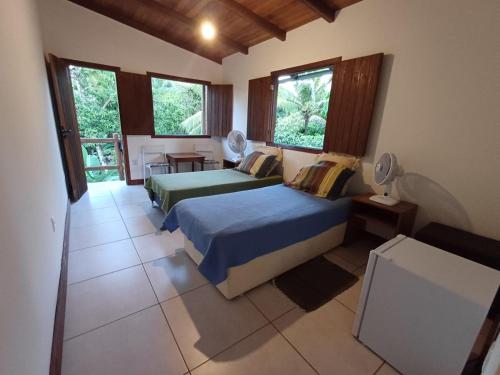 a bedroom with two beds and a balcony at Suíte Colibri - Centro de Barra Grande in Marau