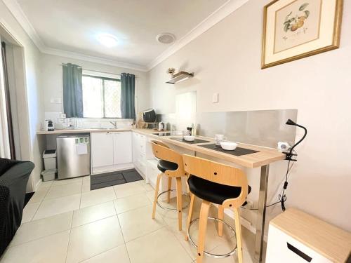 a kitchen with a table and two bar stools at 45 Private Guest Suite for 2ACParking in Perth