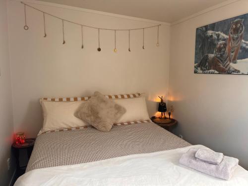 a bedroom with a bed with a towel on it at Sunsets on Harbour Kauri or Totara Cabin in Matarangi