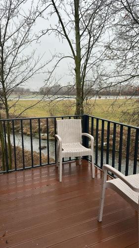 two white chairs sitting on a deck with a fence at Auszeit am Ipf in Bopfingen