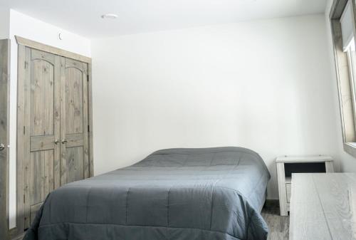 a bedroom with a bed and a wooden door at Elk Horn Cabin Rental in Valemount