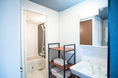 a bathroom with a sink and a mirror at H-1ビル 301 hiroshima in Hiroshima