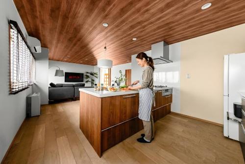 a woman standing in the kitchen of a house at The Villa Seaside in Abashiri