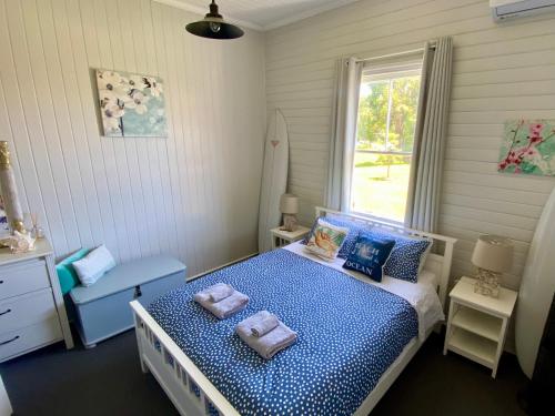 a bedroom with a bed with two towels on it at The Little River Cottage - Riverfront Retreat in Murwillumbah