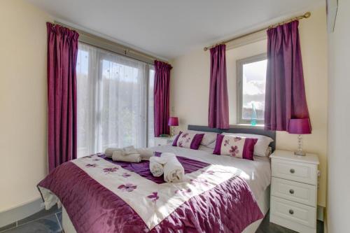 a bedroom with a purple bed with towels on it at 3 Bed in Totnes oc-bcplym in Broadhempston