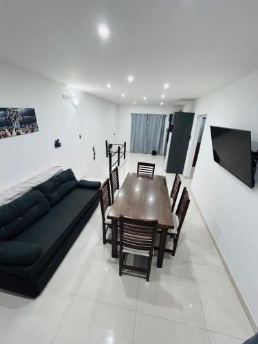 a living room with a couch and a table and chairs at Departamento ESTRADA ideal para pasajeros en tránsito, viajes laborales o estadías cortas Ubicado en Ezeiza, a solo 20 minutos del Aeropuerto Internacional Ministro Pistarini, ofrece comodidad y practicidad para hasta 4 personas in Tristán Suárez