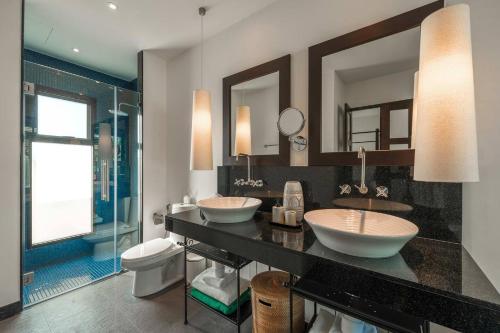 a bathroom with two sinks and a toilet and mirrors at Tranquil 4BR Garden Pool Oasis - Layan Beach in Laguna Phuket