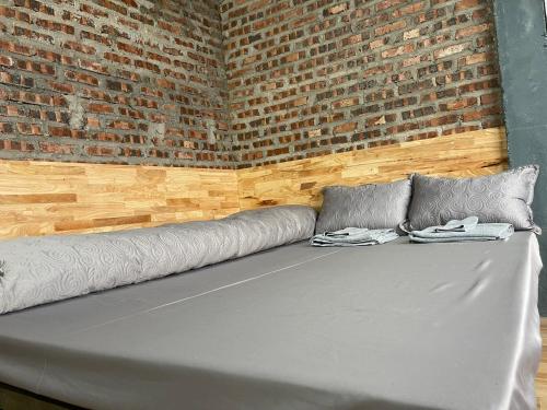 a bed in a room with a brick wall at Moutain View in Yên Minh