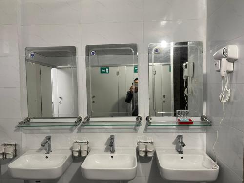 a man taking a picture of two sinks in a bathroom at Moutain View in Yên Minh