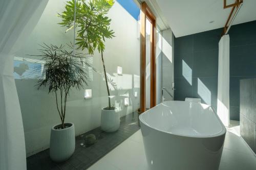 a bathroom with three potted plants and a tub at Sugar House in Wujie