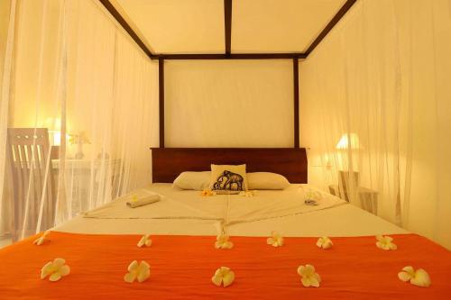 a bedroom with a bed with flowers on it at Hotel Susantha Garden in Hikkaduwa