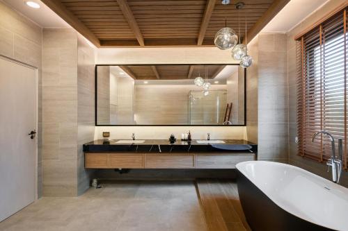 a bathroom with a tub and a large mirror at Mövenpick Pool Villa6BR-NEW2025- in Na Jomtien
