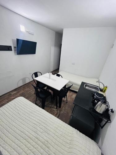 a room with a table and chairs and a bed at Departamento ESTRADA ideal para pasajeros en tránsito, viajes laborales o estadías cortas Ubicado en Ezeiza, a solo 20 minutos del Aeropuerto Internacional Ministro Pistarini, ofrece comodidad y practicidad para hasta 4 personas in Tristán Suárez