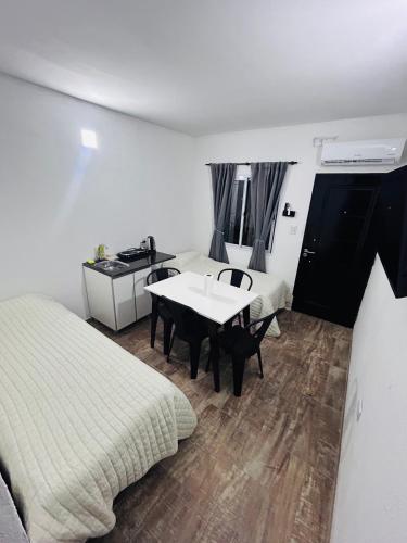 a room with a bed and a table in it at Departamento ESTRADA ideal para pasajeros en tránsito, viajes laborales o estadías cortas Ubicado en Ezeiza, a solo 20 minutos del Aeropuerto Internacional Ministro Pistarini, ofrece comodidad y practicidad para hasta 4 personas in Tristán Suárez
