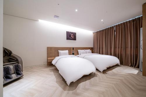two beds in a room with white walls at 루엠호텔안산 in Ansan