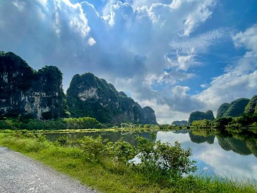 a road next to a river with mountains at Trang An Pristine View Homestay in Ninh Binh