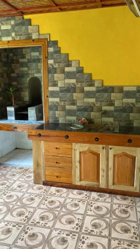a room with a stone wall and a wooden counter at Wallace and Gromit's in Siquijor
