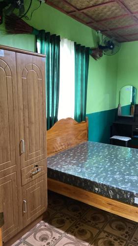 a bedroom with a wooden bed and a window at Wallace and Gromit's in Siquijor
