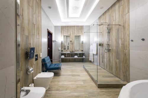 a bathroom with a shower and a toilet and a sink at Monotel Hotel in Ustʼ-Kamenogorsk