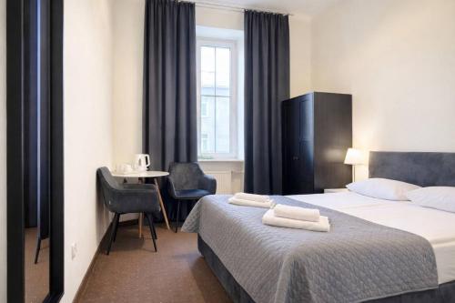 a hotel room with a bed with two towels on it at Hotel Mazowiecki WOW in Warsaw